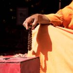 Image of a sadhu sitting in a meditation pose with beads