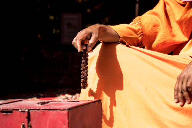 Image of a sadhu sitting in a meditation pose with beads