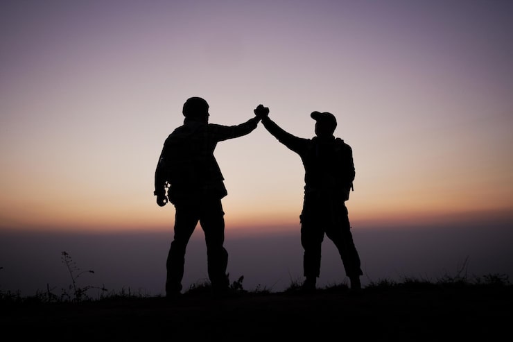 silhouette-teamwork-helping-hand-trust-help-success-mountains-hikers-celebrate-with-hands-up-help-each-other-top-mountain-sunset-landscape_1150-61310